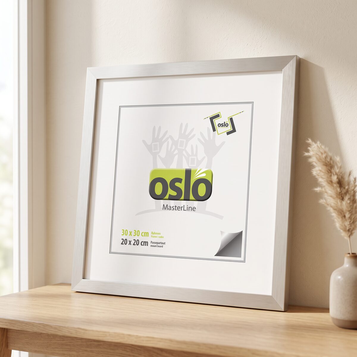 Illustration: silberner OSLO MasterLine Rahmen im Format 30 × 30 cm mit weißem Passepartout für ein 20 × 20 cm Bild, auf einem Holztisch vor heller Wand