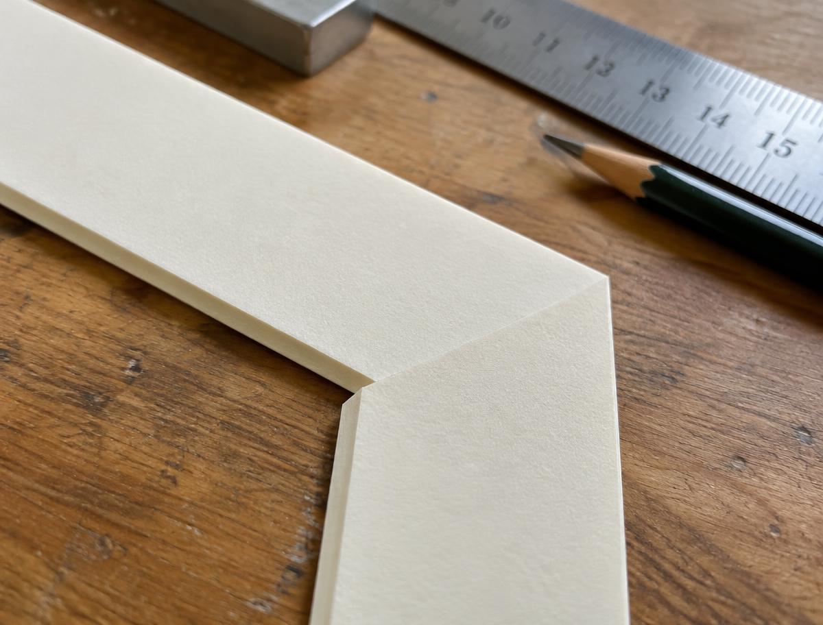 Schräg geschnittene Passepartout-Ecke mit Lineal und Bleistift